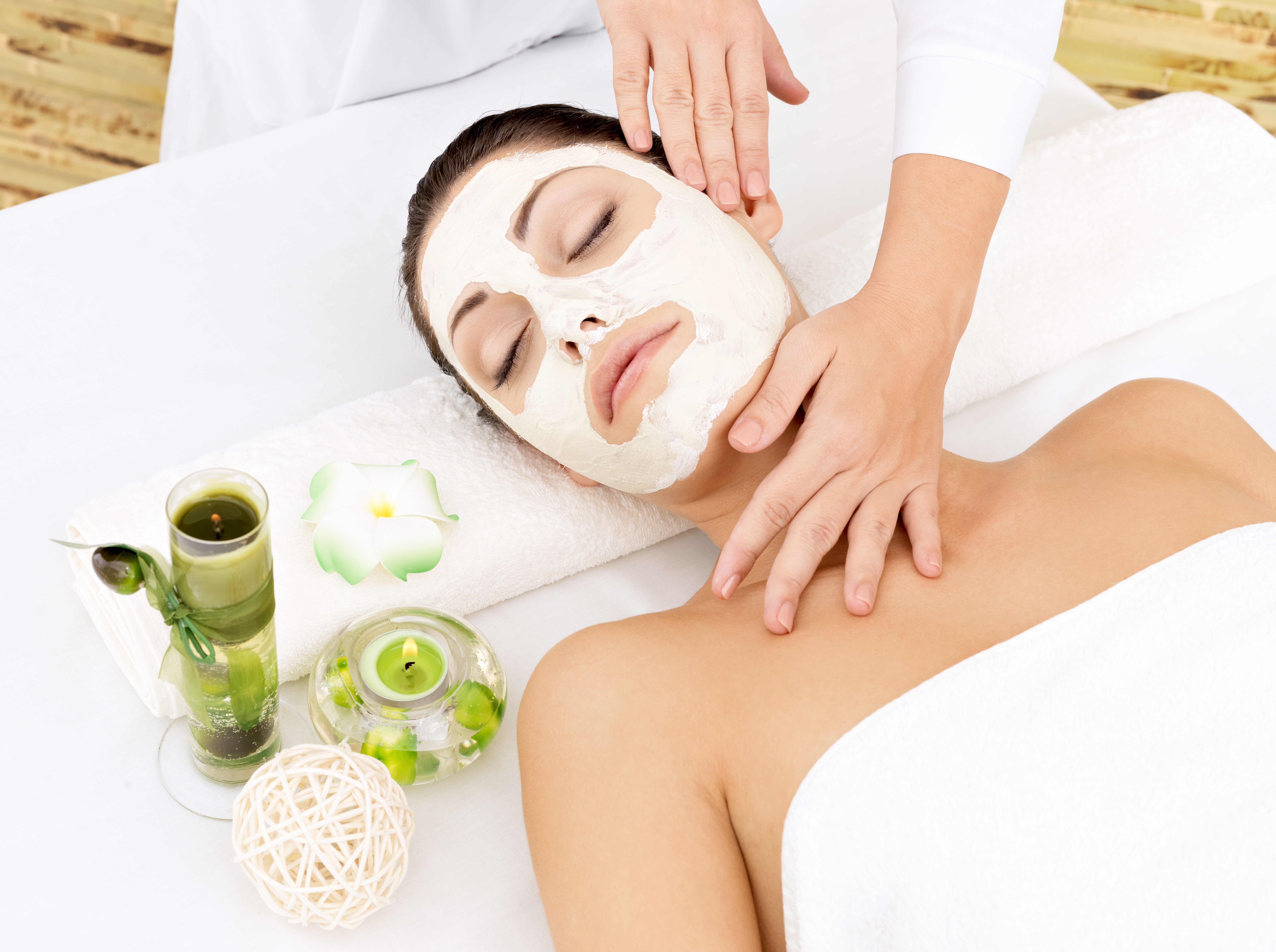 Young woman at spa salon with cosmetic mask on face. High angle photo